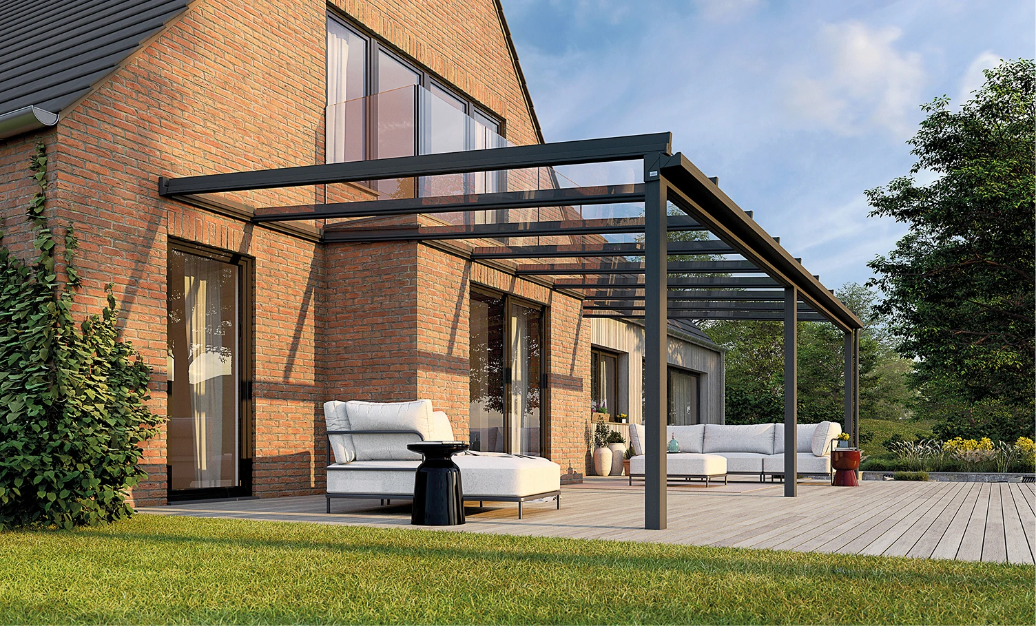 Brick house with glass-panel pergola over a wooden deck and white outdoor seating